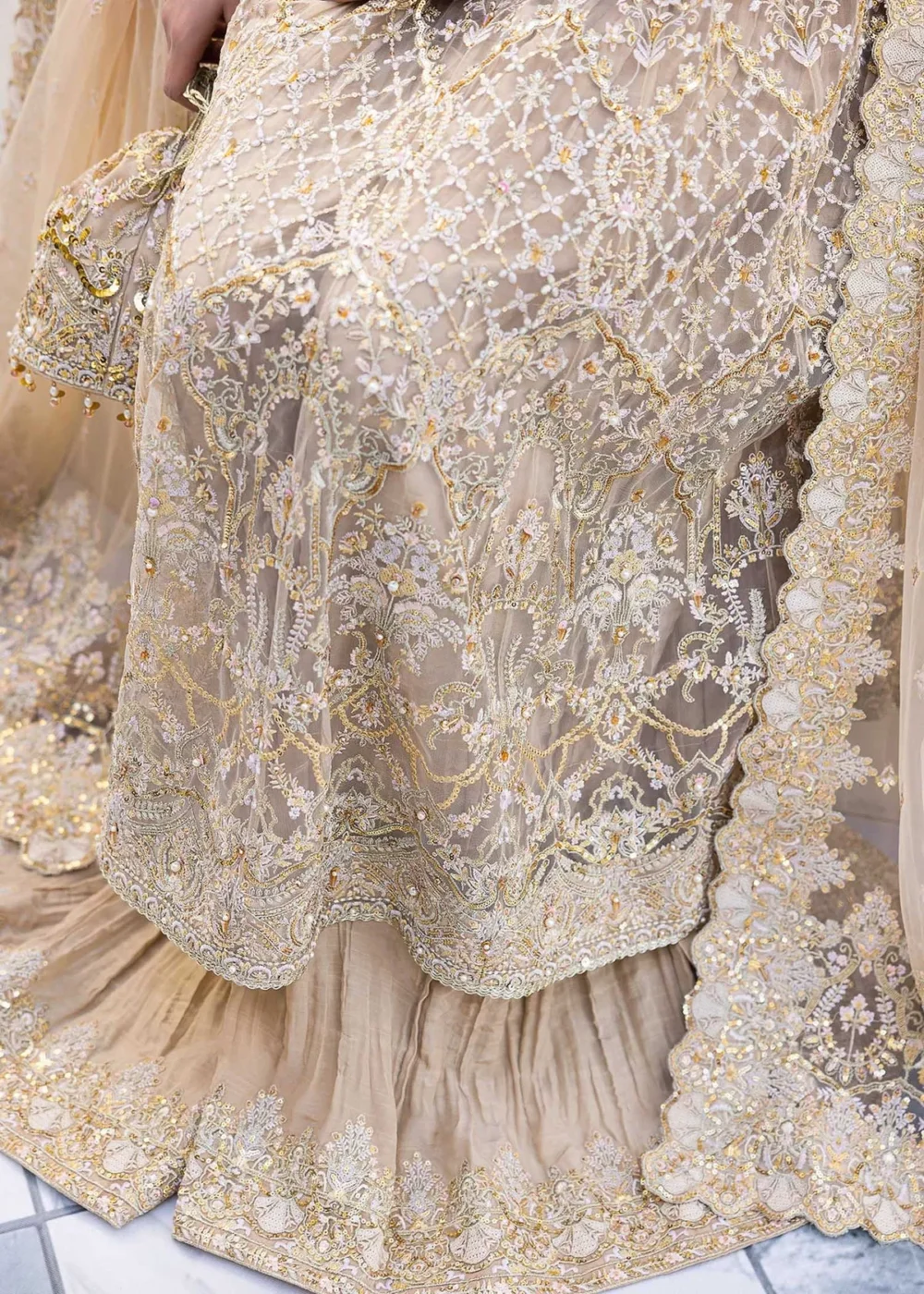 Nude Peshwas ensemble with delicate embroidery and shimmering embellishments