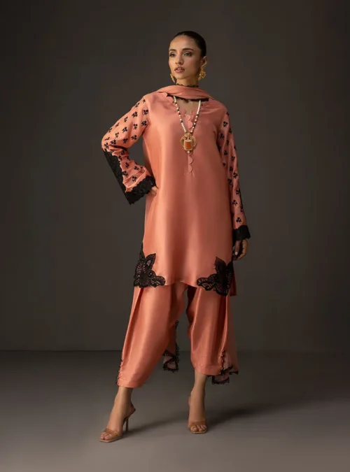 Detail shot of the tussle silk fabric and the elegant drape of the shalwar from the coral embroidered suit.
