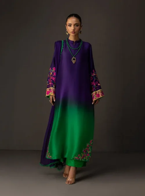 Detail shot of the vibrant, colorful embroidered border on the emerald hemline of the gradient embroidered suit.